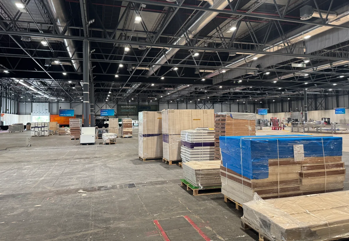Empty exhibition hall with pallets of wrapped stand parts, ready for the build