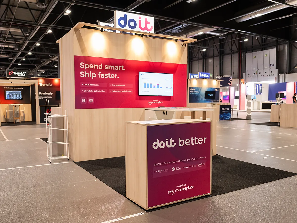 DoiT stand from the other side, with the red print wall, the screen and the counter with the logo
