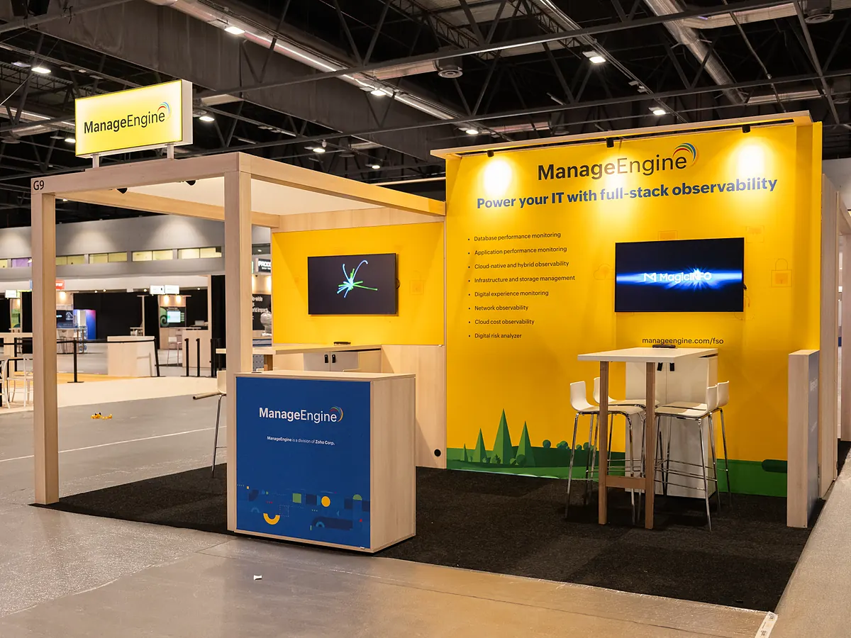 ManageEngine stand with a yellow full colour print wall, two screens and a printed counter