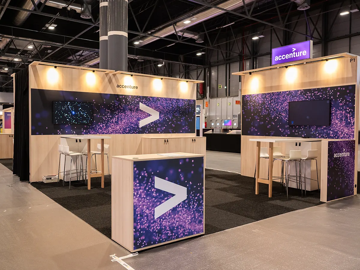 Accenture corner stand with a purple starry print on the walls, a screen and a counter with the logo