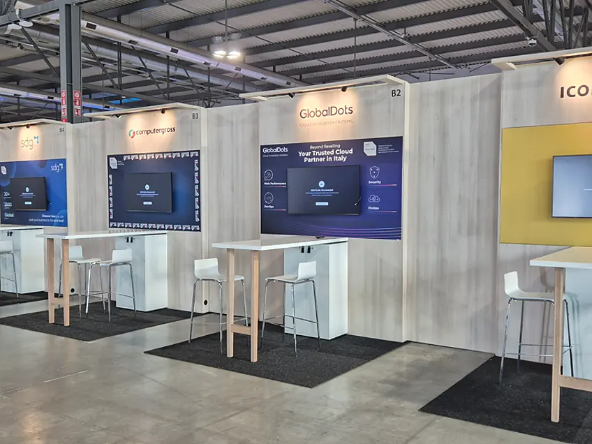 Row of linked stands including GlobalDots and iconsulting, each with its own print wall, screen and high table