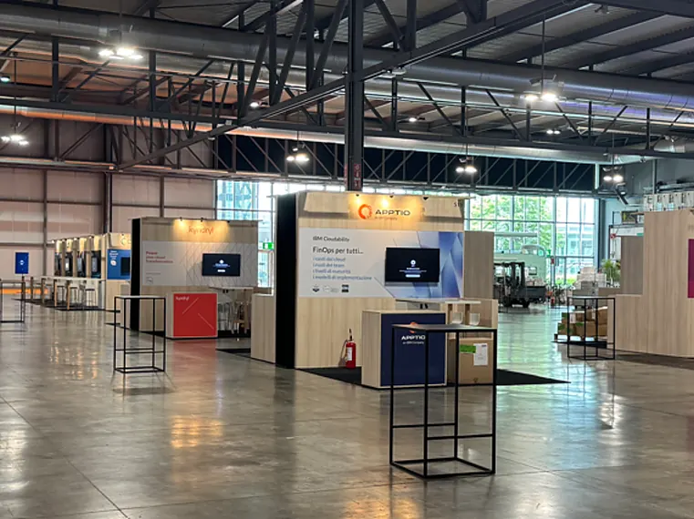 Overview of an exhibition hall with rows of linked stands with print walls and screens