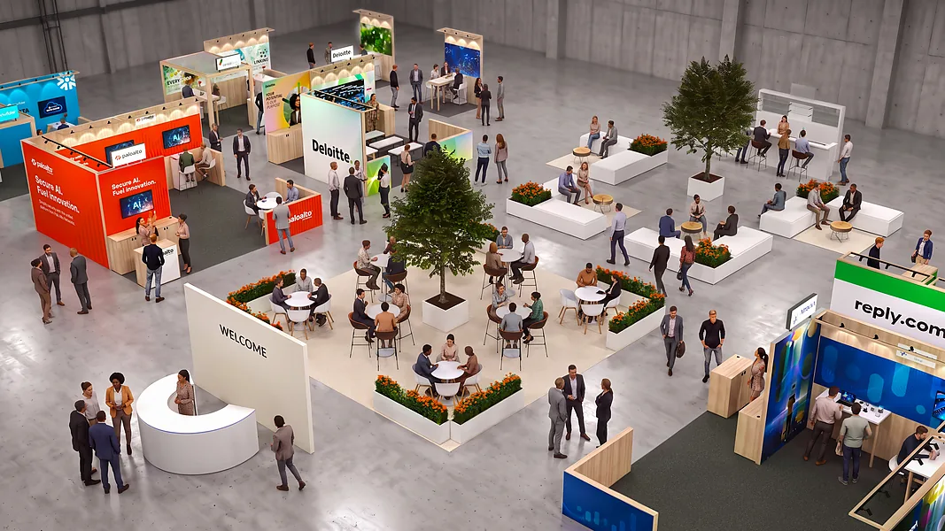 Beursplein van bovenaf met een ronde ontvangstbalie met WELCOME, zitpleinen met tafels en stands eromheen
