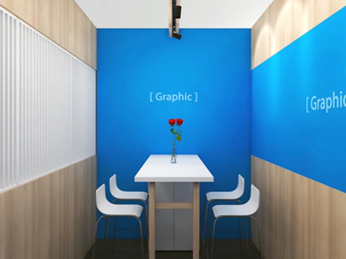 Dichte vergaderruimte in een stand, met een tafel voor twee tussen wanden met full color print